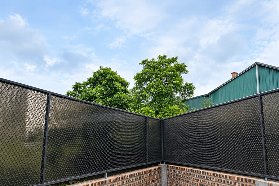 Hàng rào tấm Polycarbonate màu nâu trà kết hợp khung và lưới kim loại bao quanh góc khuôn viên.